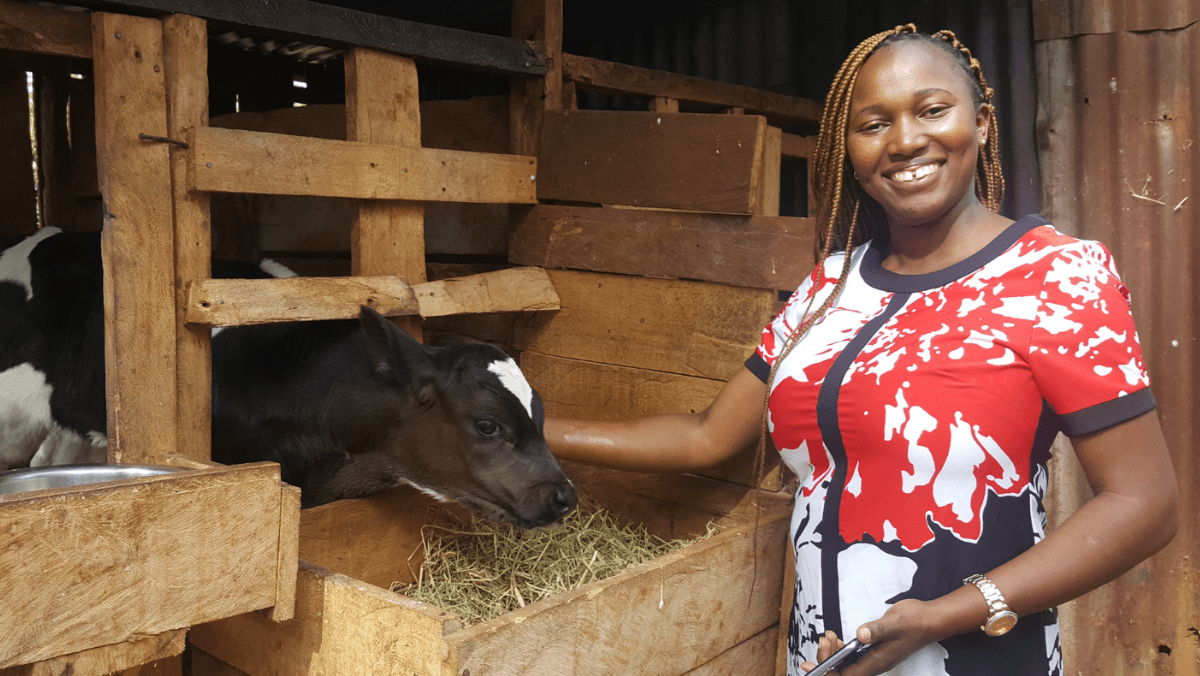 Esther, a VWB/VSF staff member, stands with a calf